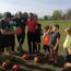 gruppo di adulti e bambini in un campo da rugby con palloni